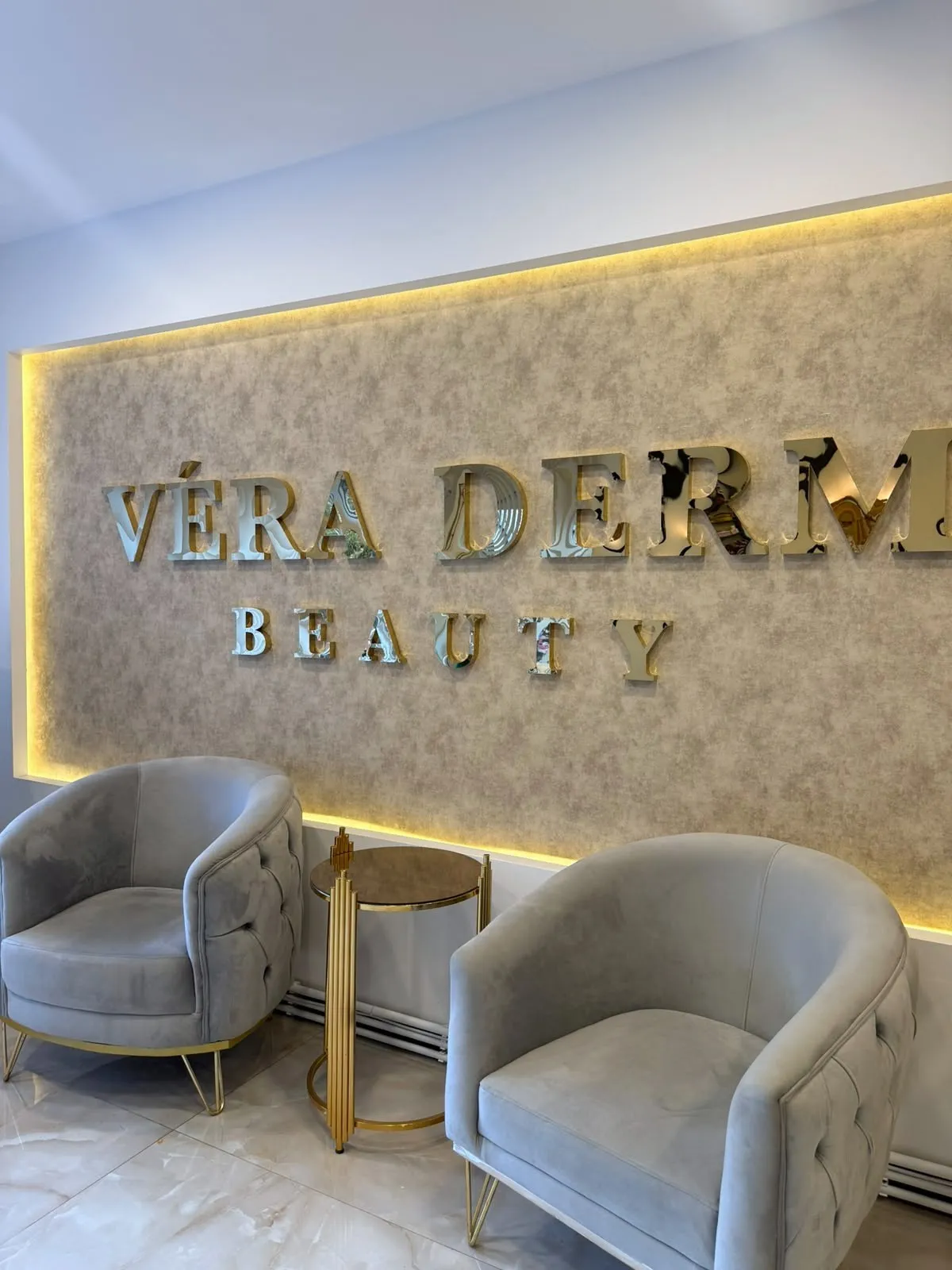 VÉRA DERM BEAUTY aydınlatmalı marka duvarı ve bekleme koltukları